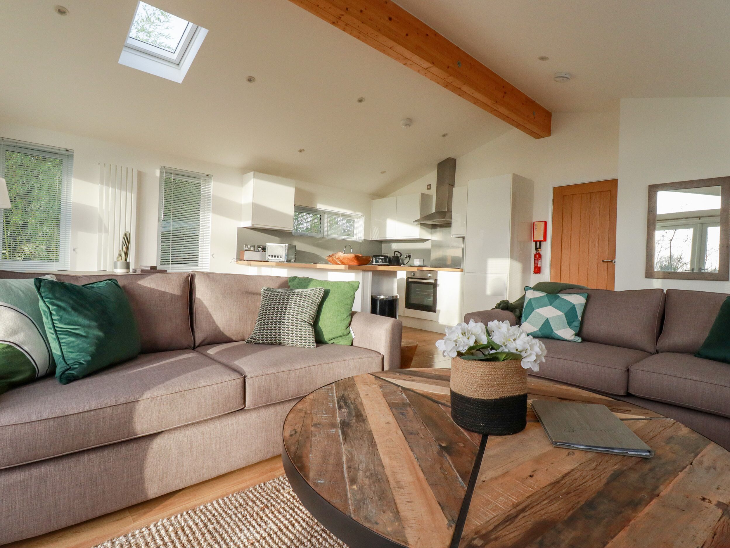 A modern living room with a sofa, coffee table, and kitchen in the background.