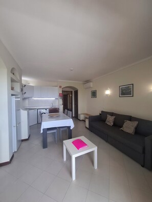 A compact living space with a kitchenette, dining area, and a sofa.
