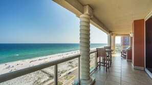 Ein Balkon mit Blick auf Strand und Meer.