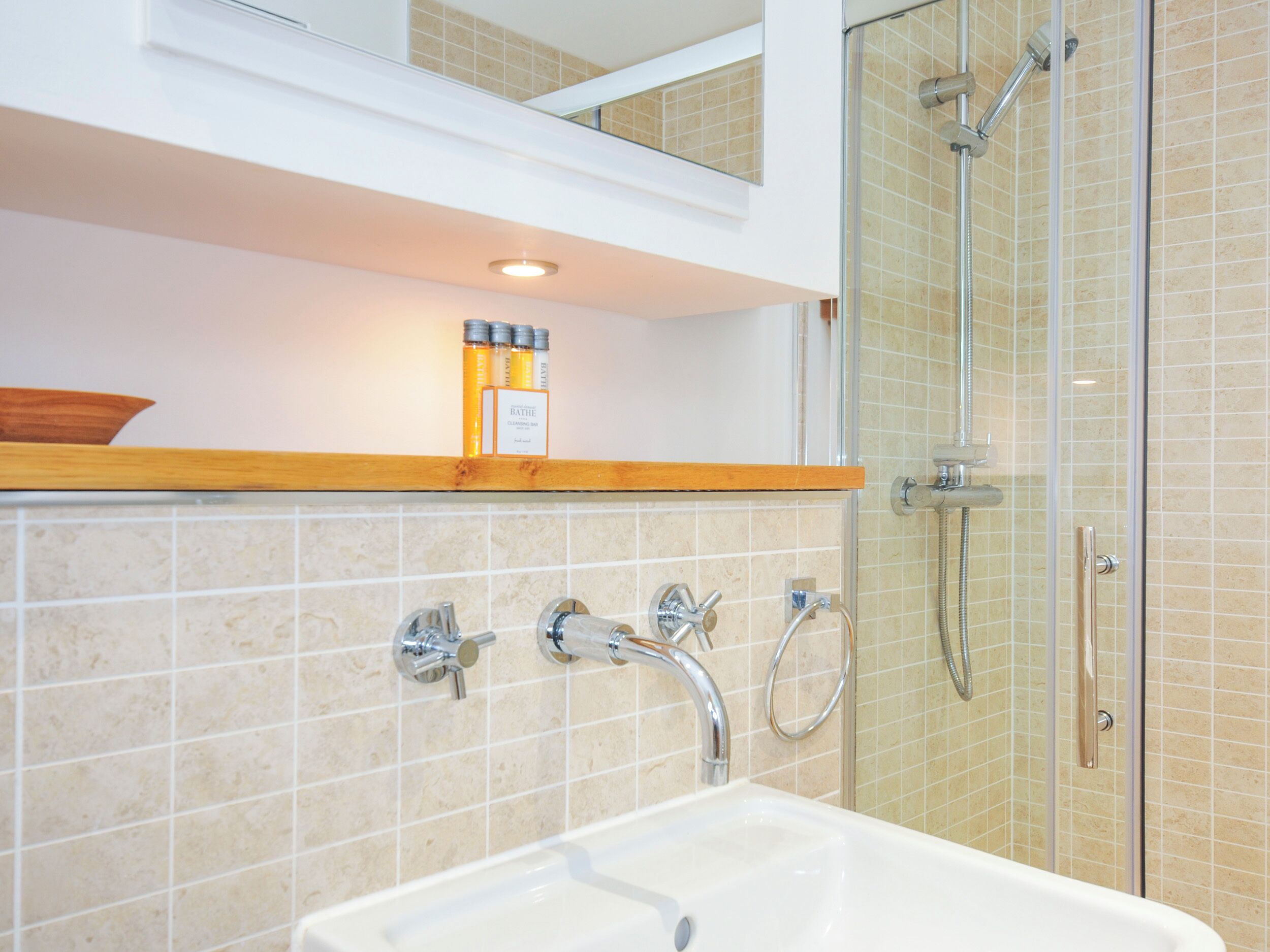 A bathroom with a bathtub, a shower, and a vanity with a mirror.