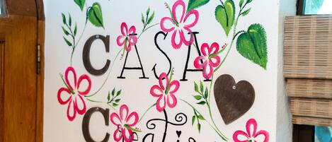 Een muur met de tekst "CASA Creativa" omringd door bloemmotieven.
