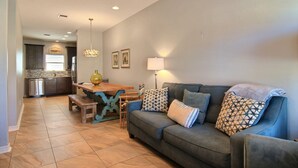 A living room with a sofa, a wooden table, and a lamp. - Family Tides Beach House by Silver Sands Vacation Rentals (Port Aransas)