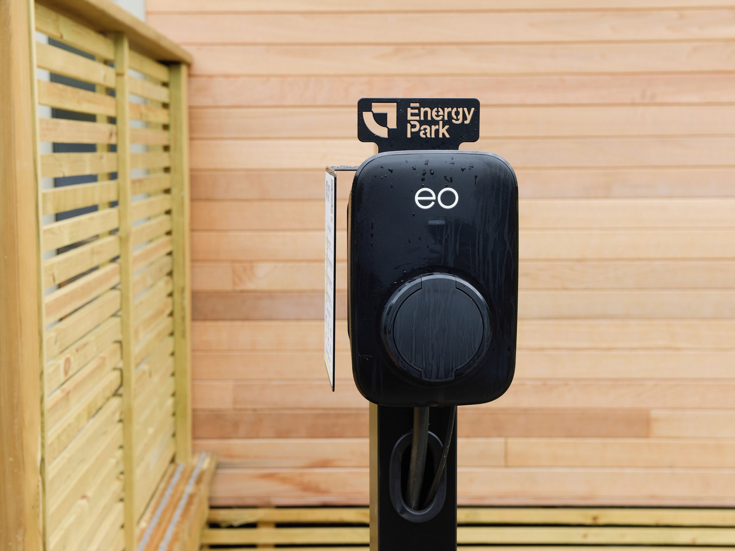 En skylt för en energipark med en svart laddstation.