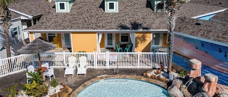 A house with a swimming pool, a fenced patio area, and a view of the ocean.