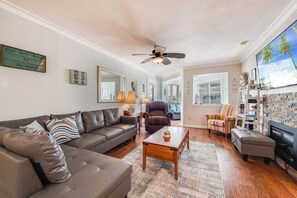 A living room with a brown leather sofa, a wooden coffee table, and a fireplace. - Gulf Breeze by Silver Sands Vacation Rentals (Port Aransas)