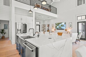 A spacious kitchen with a large island, modern appliances, and a high ceiling with exposed beams. - Hooty And The Blowfish by Silver Sands Vacation Rentals (Port Aransas)