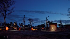 A building with a giraffe enclosure at dusk. - Safari Hotel Beekse Bergen (Hilvarenbeek)