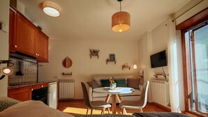 Un espace de vie compact comprenant un coin cuisine, un espace repas et un lit.