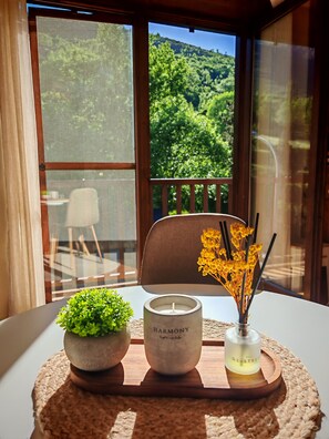 A table with a candle, a small plant, and a vase with flowers.