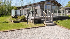 A modern wooden building with large windows and a covered outdoor area. - 7 Meadow Retreat (Liskeard)