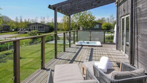 A wooden deck with a hot tub, lounge chairs, and a pergola. - 11 Meadow Retreat (Liskeard)