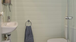 A bathroom with a white sink, a toilet, and a glass shower enclosure. - Privet Pod - UK41394 (Lathom, near Southport)