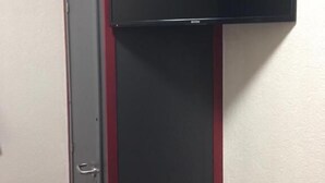 A room with a closed door and a black cabinet with a red trim. - P&P V-V UG (Stuttgart)