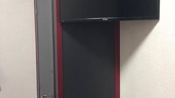 Ein Zimmer mit geschlossener Tür und einem schwarzen Schrank mit roter Zierleiste.