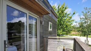 A balcony with a glass table, a bottle of wine, and two wine glasses. - 12 Meadow Retreat (Liskeard)