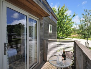 A balcony with a glass table, a bottle of wine, and two wine glasses. - 12 Meadow Retreat (Liskeard)