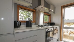 Een moderne keuken met een groot raam, een inbouwoven en een magnetron.