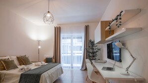Une chambre d’hôtel moderne équipée d’un lit, d’un bureau et d’un ordinateur.