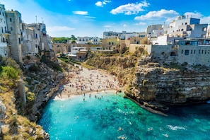 A coastal town with a beach, rocky cliffs, and historic buildings. - [Central Station ★★★★★] Elegant Apartment (BARI)