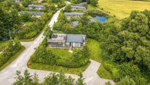 A residential area with houses surrounded by lush greenery and fields. - 9 Meadow Retreat (Liskeard)