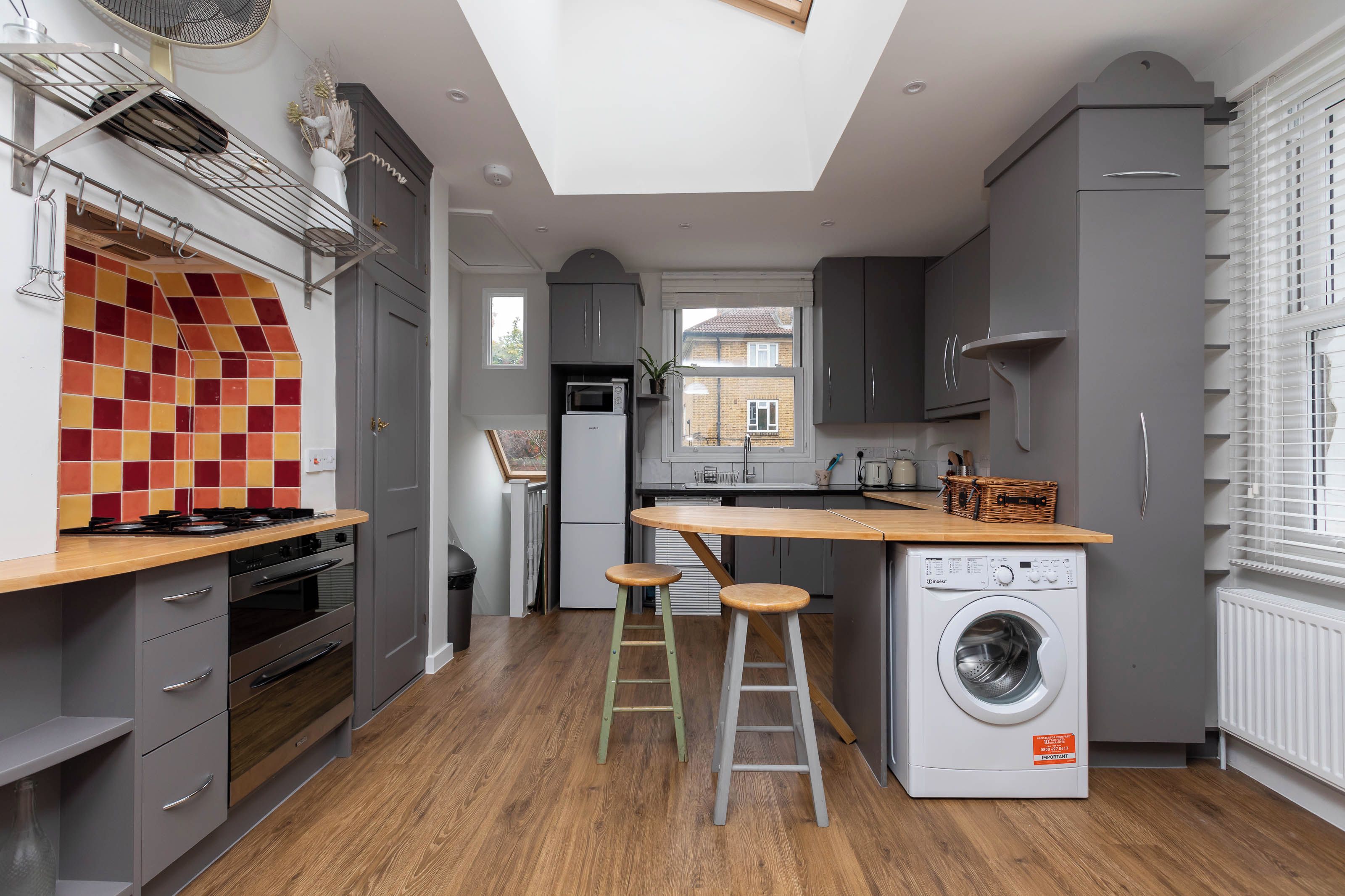 A modern kitchen with a central island, built-in appliances, and a view to the outside.