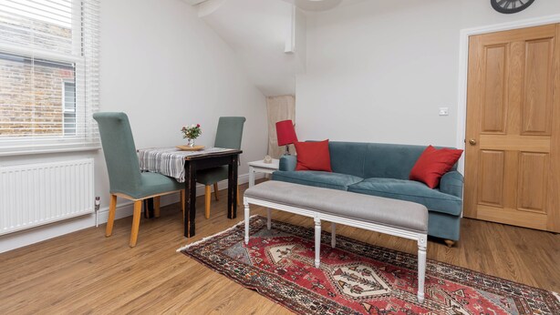 Una habitación acogedora con una mesa de comedor, sillas, un sofá y un banco.
