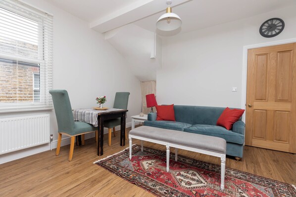 A cozy room with a dining table, chairs, a sofa, and a bench.