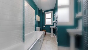 Un baño con bañera, inodoro y lavamanos.