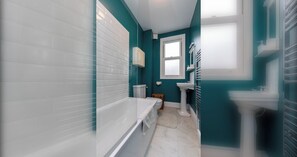 A bathroom with a bathtub, toilet, and sink.