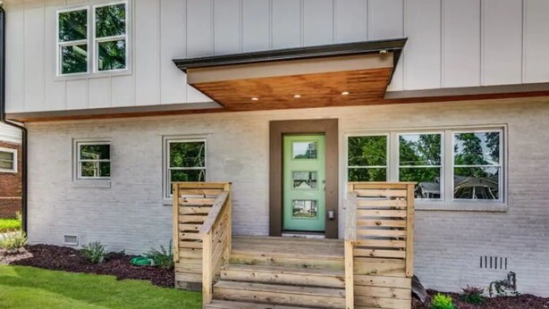 A two-story house with a green front door, wooden steps, and a small porch. - Modern relaxing home w/ movie room & massage chair (Atlanta)