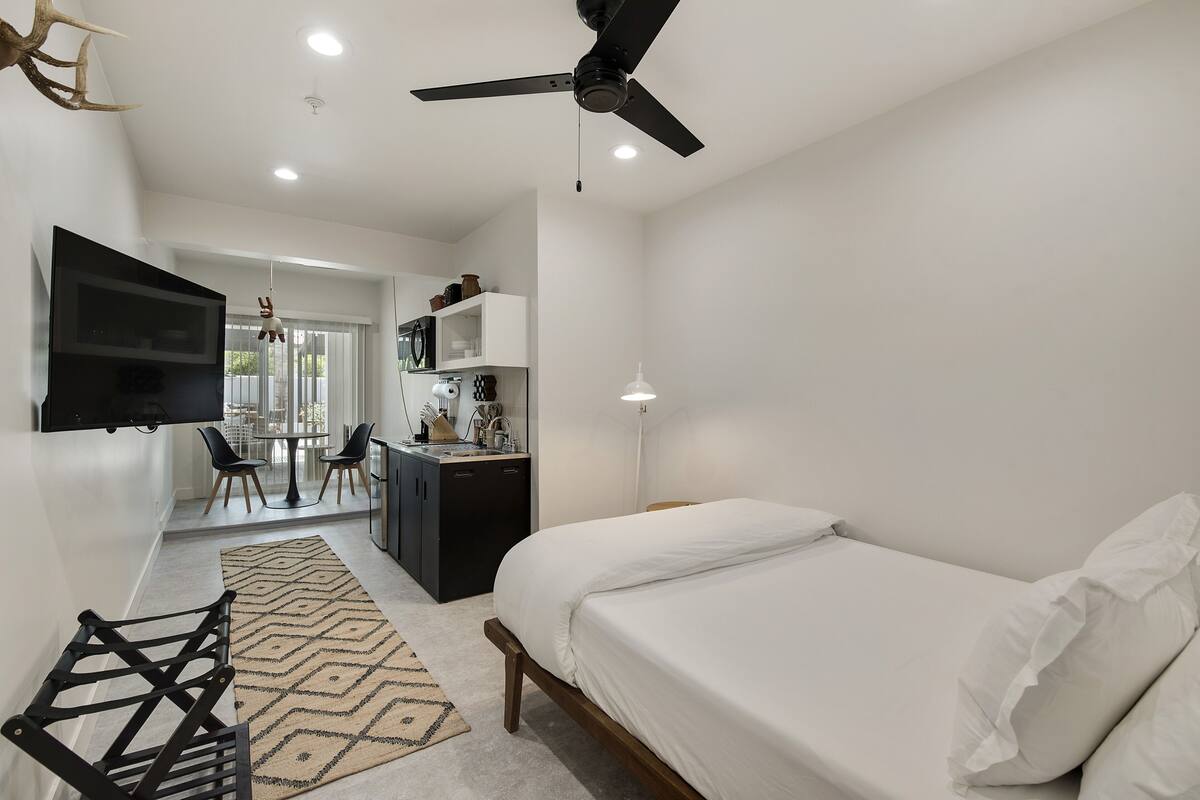 Une chambre à coucher moderne avec un lit, un bureau et un téléviseur.
