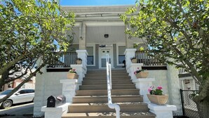A set of concrete steps leading to a building entrance with a mailbox on the left.