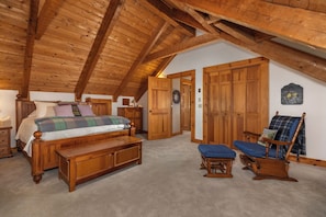 A bedroom with a wooden ceiling, a bed, a bench, a chair, and wooden wardrobes. - Hounds Retreat Pet Friendly, Wood Fireplace, HotTub, WiFi, Decks (Ferguson)