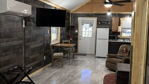 A compact kitchen with a refrigerator, microwave, and wooden cabinets. - The Coop.  A lil taste of country with horses and chickens. (Scott)