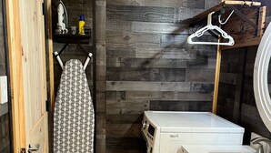 A compact laundry room with a washing machine, a drying rack, and a sink. - The Coop.  A lil taste of country with horses and chickens. (Scott)