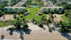 Un resort con varias edificaciones, una piscina central y acceso directo a la playa.