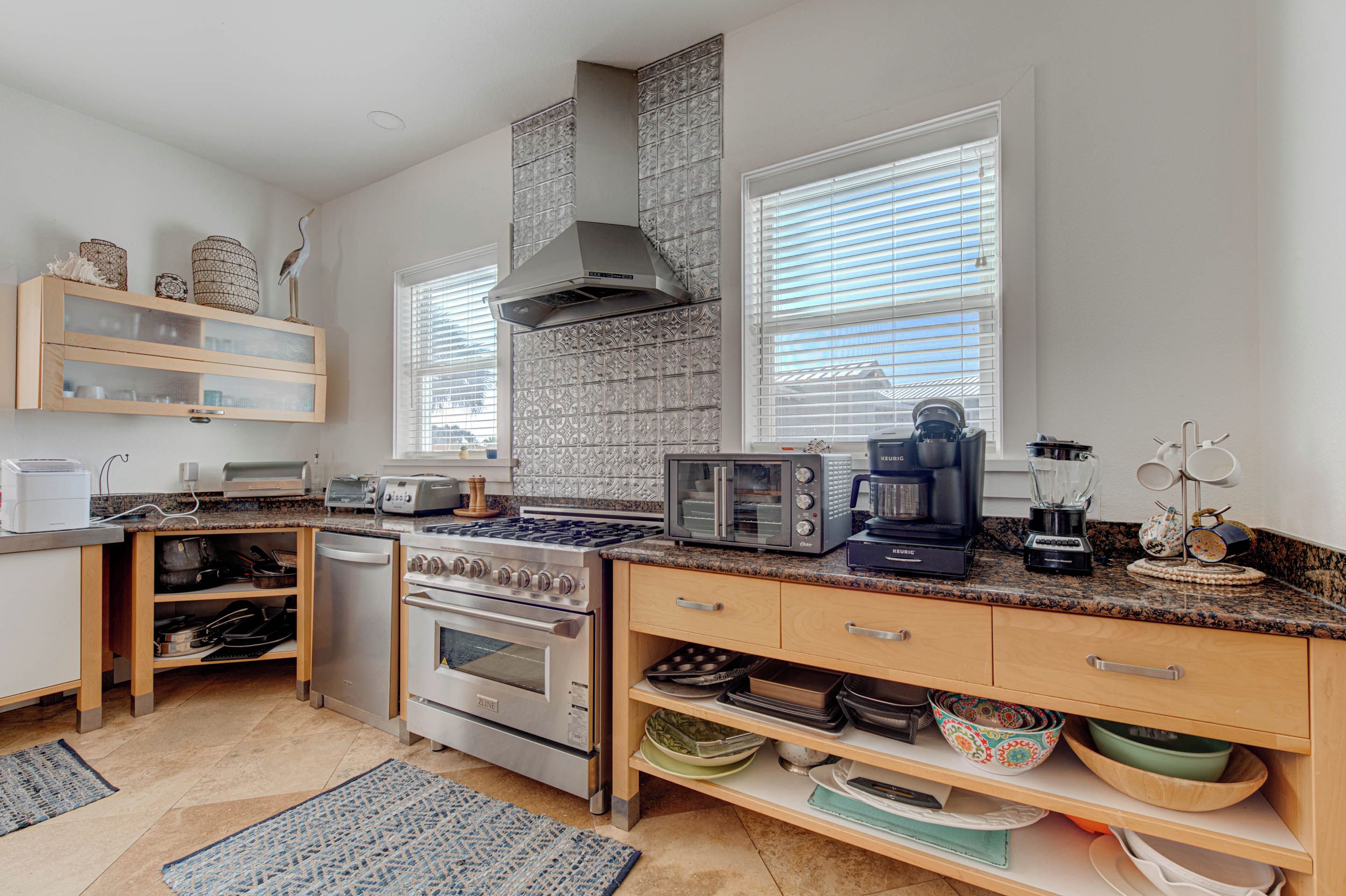 A modern kitchen with granite countertops, stainless steel appliances, and a built-in oven.