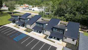 Een modern gebouwcomplex met meerdere eenheden, een parkeerplaats met aangepaste toegankelijkheid en een tankstation op de achtergrond.