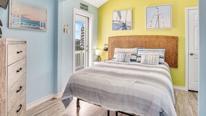 Un dormitorio con cama, cómoda y puerta.