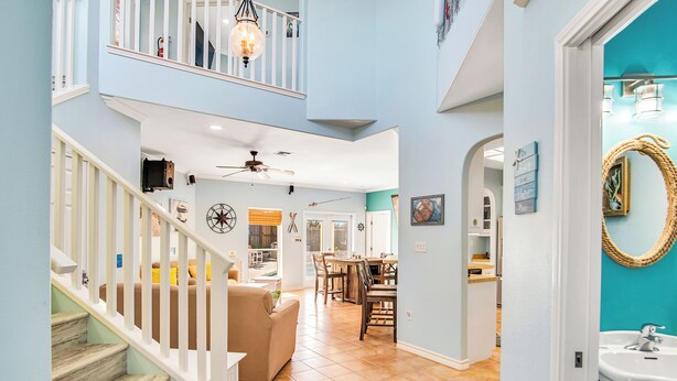 A spacious interior with a staircase, a dining area, and a kitchen. - LaJuana Iguana by Silver Sands Vacation Rentals (Port Aransas)