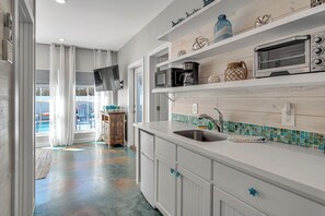 A modern kitchen with white cabinetry, a stainless steel sink, and a built-in oven. - Nauti Beach by Silver Sands Vacation Rentals (Port Aransas)