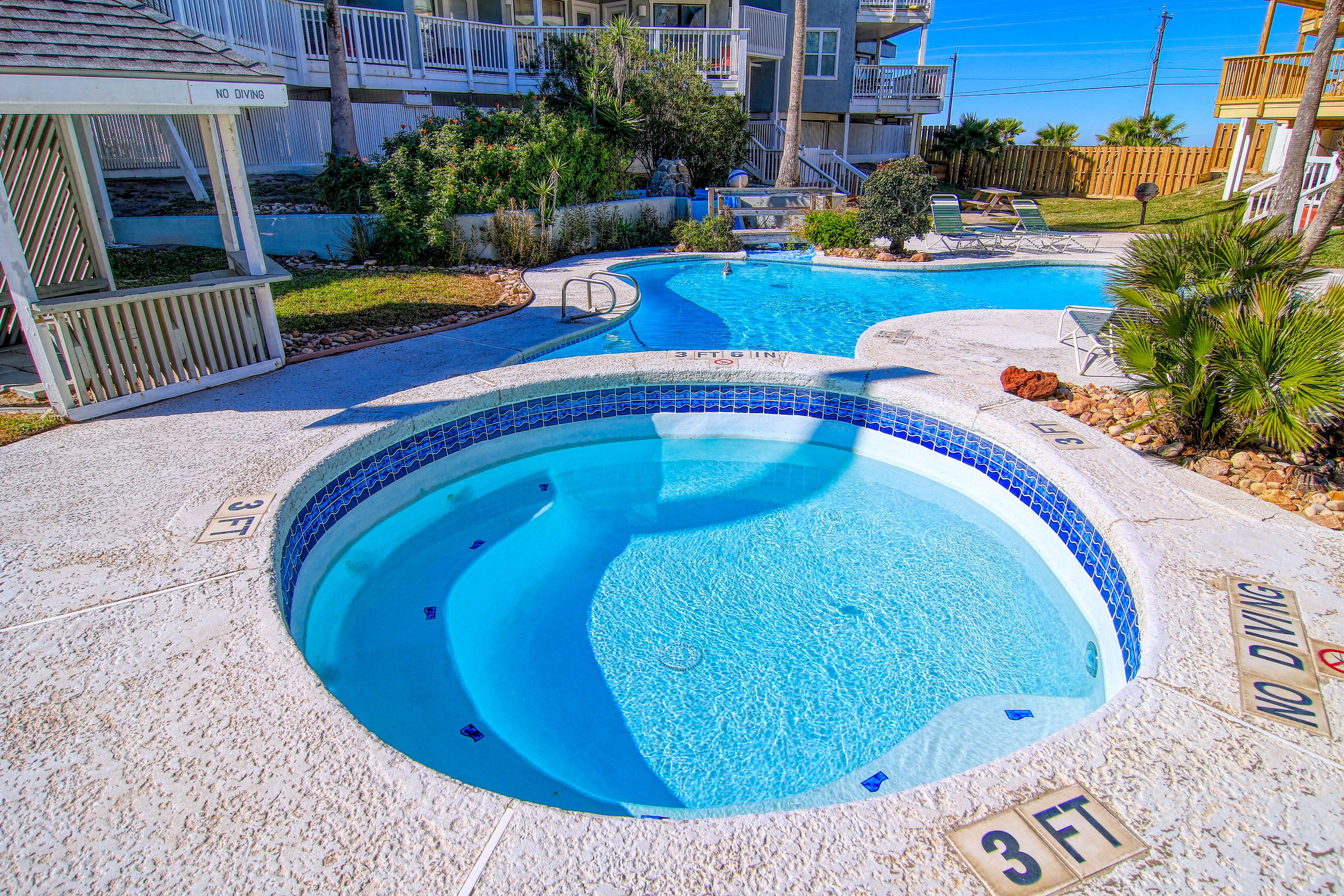A swimming pool with a 'No Diving' sign, surrounded by a deck area with lounge chairs and a small waterfall feature.