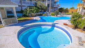 A swimming pool with a 'No Diving' sign, surrounded by a deck area with lounge chairs and a small waterfall feature. - My Happy Place by Silver Sands Vacation Rentals (Port Aransas)