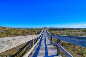 A wooden boardwalk leading to the beach with a clear blue sky. - My Happy Place by Silver Sands Vacation Rentals (Port Aransas)