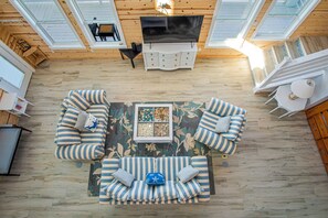 A spacious living area with a large sofa set, a coffee table, and a TV.