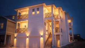 A multi-story house with a garage, a balcony with railing, and a staircase.