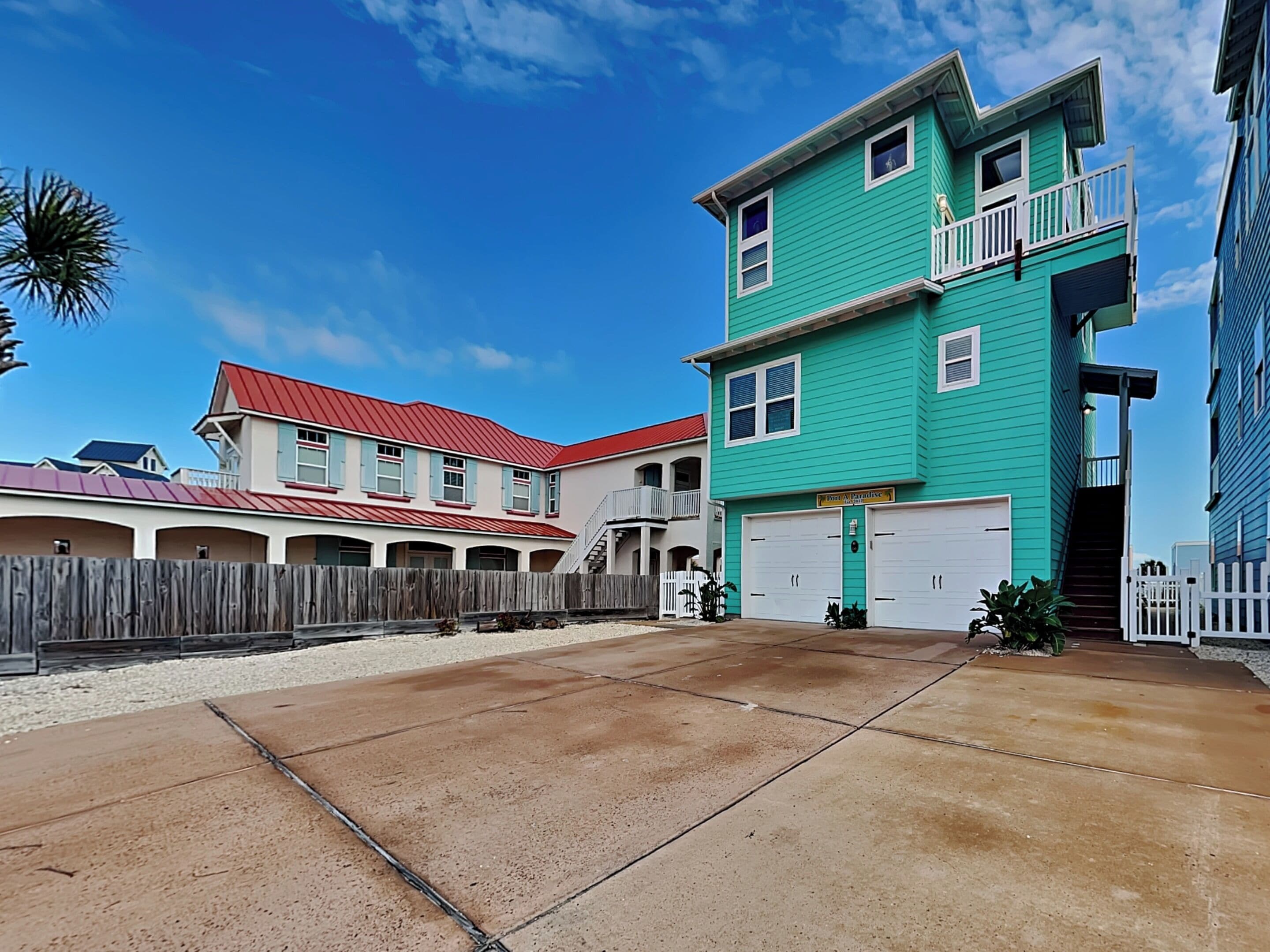 A residential area with a two-story house featuring a balcony and a garage.