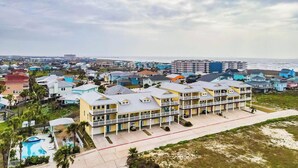 Un hôtel situé sur la côte, doté de nombreux balcons et d’un espace piscine.