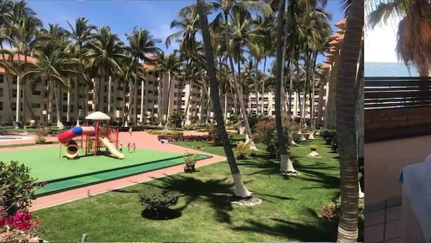 A hotel with a children's play area, palm trees, and a view of the ocean. - Costa Vallarta by TRVL2HM (Nuevo Nayarit)