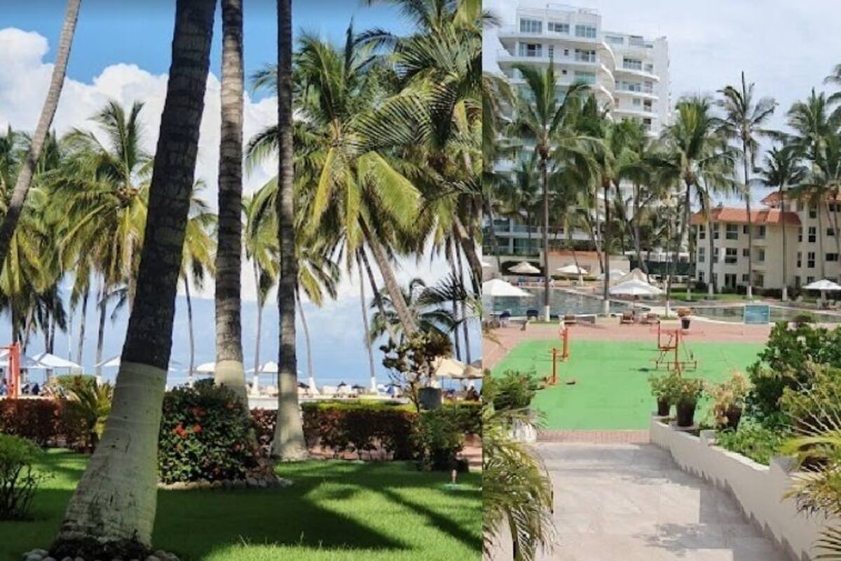Zona d'una piscina de resort amb palmeres, una font i un edifici al fons.